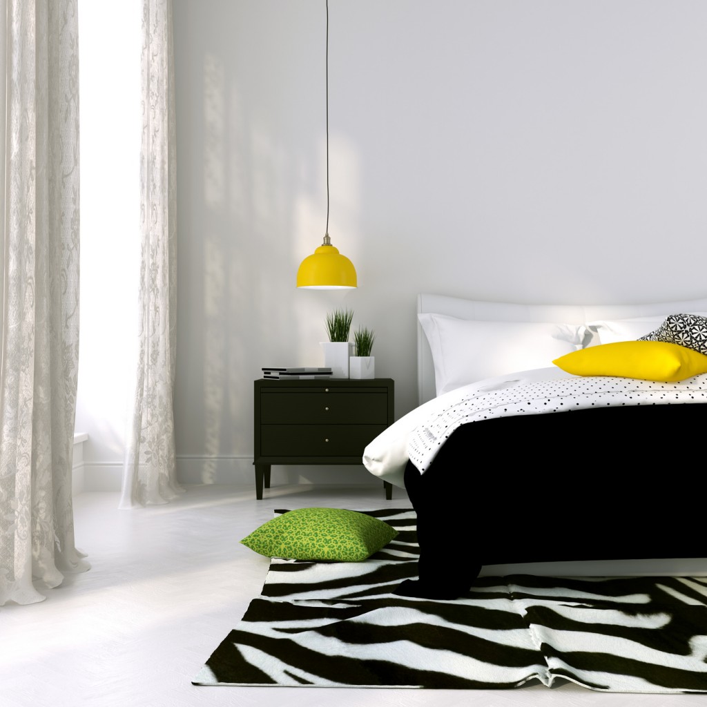 Bedroom in black and white with the yellow lamp and colored cushions